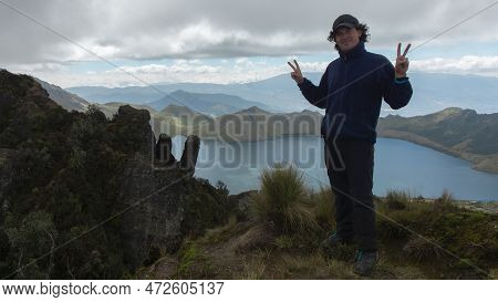 Young Male Climber Standing On The Summit Of Cerro Negro Next To The Mojanda Lagoon Wearing Cap And 