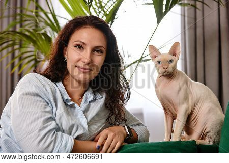 Portrait Of Young Woman Holding Cute Cat With Blue Eyes. Female Hugging Her Cute Short Hair Kitty. B