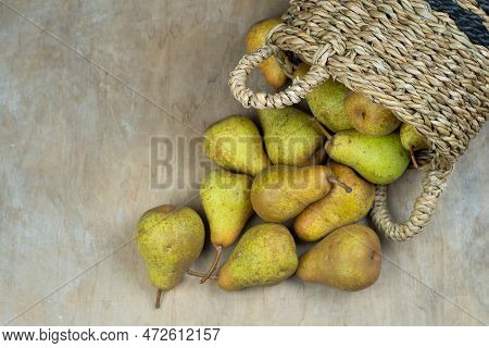Pears In Basket On A Wooden Background. Fruit Harvest. Autumn Still Life. Pear Variety Bera Conferen