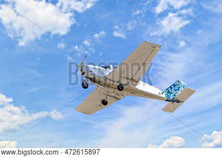 Single Engine Ultralight Plane Flying In The Blue Sky With White Clouds