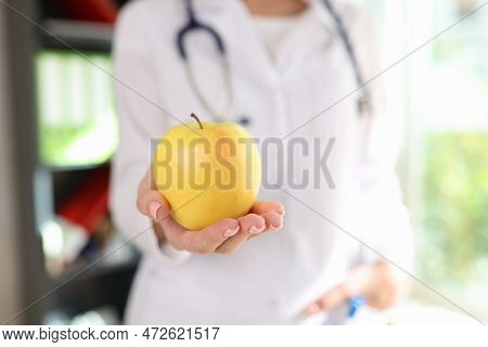 Ripe Yellow Apple In Hand Of Female Nutritionist, Healthy Eating Concept. Dietologist Advises Organi