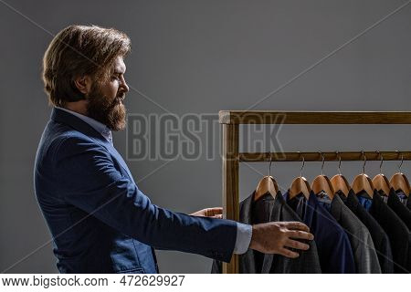 Male Suits Hanging In A Row. Men Clothing, Boutiques. Tailor, Tailoring. Stylish Mens Suit. Man Suit