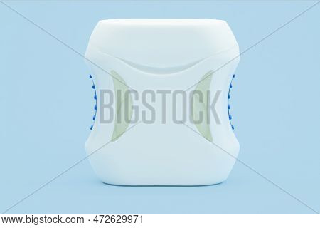Container With Dental Floss. Dental Floss On A Blue Background. Close Up Of Young Female Hands Holdi