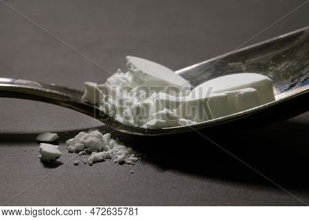Pharmaceutical Medicine Drugs Powder On A Silver Metal Spoon. Smashed Remedy, Tablets, On Top Of A G