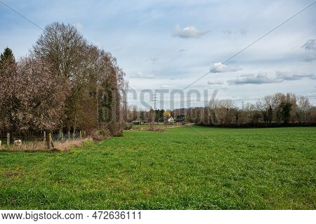 Green Meadows And Agriculture Fields With Farmhouses In The Background During Spring Around Ternat, 