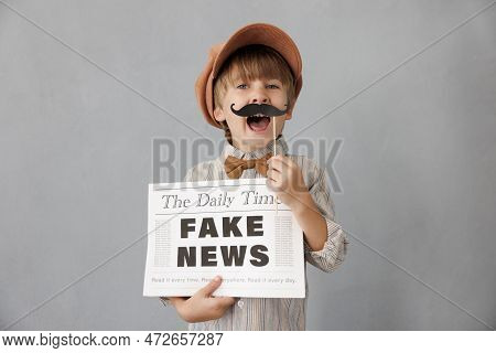 Newsboy Shouting Against Grunge Wall Background. Boy Selling Fake News