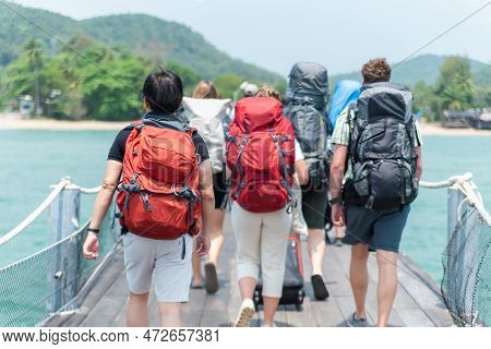 Travel And Vacation Concept: Group Of Travelers With Travel Bags Walking The Boat From The Port.