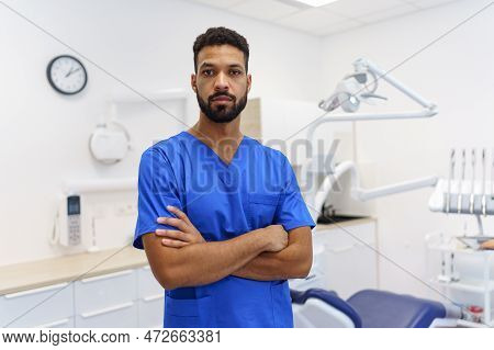 Portrait Of Young Multiracial Dentist At Private Dental Clinic.