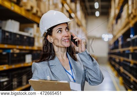 Manager Woman In Suit Calling In A Waehouse.