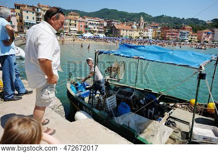 San Terenzo, Italy - May 2011: Tourists And Locals Watching Fishermen In Small Fishing Boat With Equ