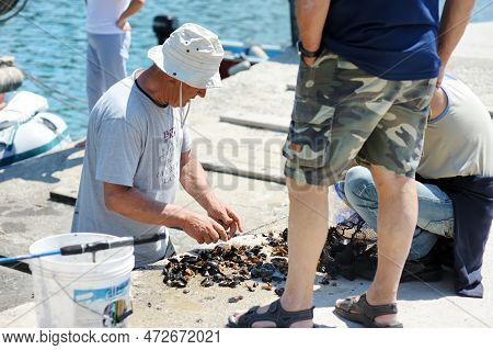 San Terenzo, Italy - May 2011: Tourists And Locals Watching Fishermen In Small Fishing Boat With Equ