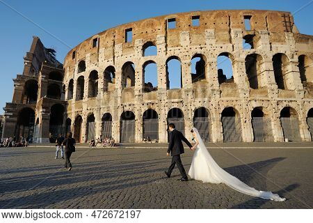 Rome, Italy - May 2011: Wedding Couple In Front Of Colosseum, Monumental Roman Amphitheater Once Use