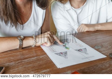Tver, Russia - August 2, 2021. A Woman In A Cafe At A Table Is Studying The Design Of A Person. The 