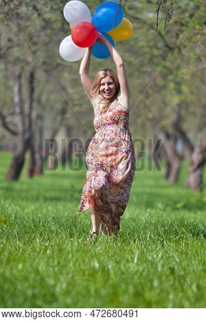 Youth Lifestyle Concept. Young Caucasian Blond Female With Bunch Of Colorful Air Balloons Running In