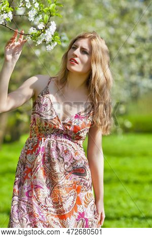 Modern Lifestyle Concepts. Portrait Of Winsome Blond Caucasian Adult Girl Posing Outside In Green Fo