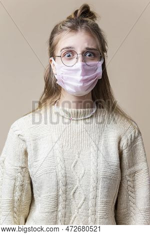 Calm Caucasian Blond Female Girl In Round Glasses Wearing Warm Knitted Sweater Using Viral Facial Pr
