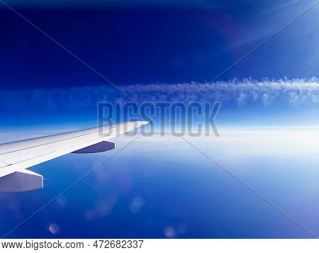Aerial View Through Frozen Porthole Of Plane Exhaust And Blue Sky. Scenic View Through Aircraft. Air
