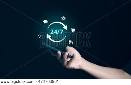 Man Hand Holding Phone With Icon Virtual 24-7 On For Worldwide Nonstop And Full-time Available Conta