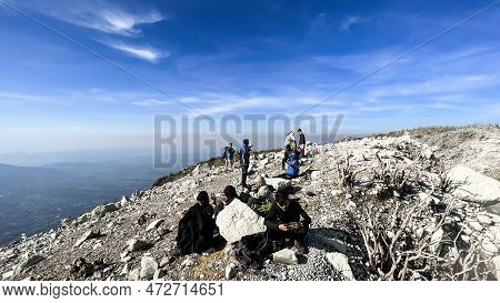 A Group Man Standing On Top Of A Nearby Mountain Looking At Mount Sindoro. West Java, Indonesia, Mar