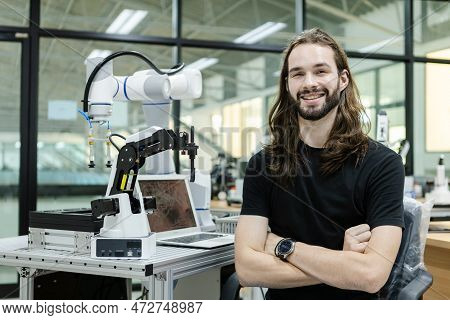 Male Staff Engineer Sitting Crossed Arms With Robot For Education Ontable At Class Room. Education C
