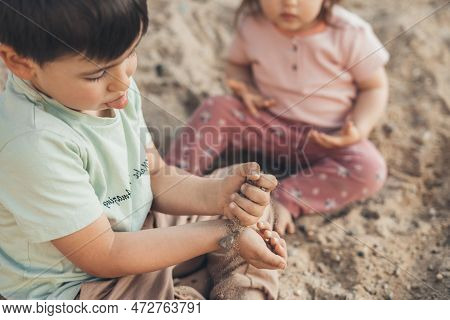 Two Muddy Child Playing In The Wet Dirt Sand Having Fun As They Diging. He Is Enjoying Summer Break 