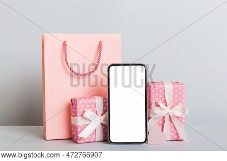 Mobile Phone With Blank Screen On Colored Background With Hearts, Calendar And Gift Box, Valentine D