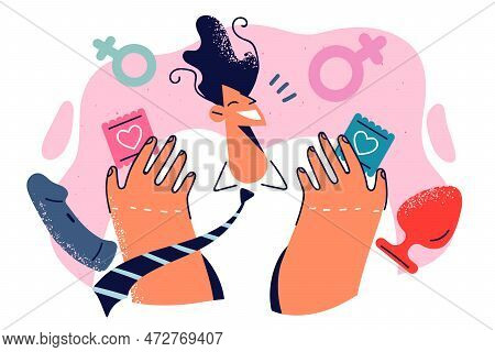 Relaxed Man Smiles While Standing In Sexshop Among Condoms And Toys For Adults Bought In Store. Guy 