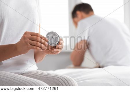 Couple In Bedroom. Woman With Blister Of Emergency Contraception Pill, Closeup