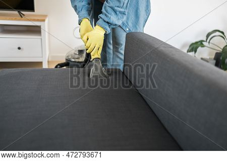 Man Holding Modern Washing Vacuum Cleaner And Cleaning Dirty Sofa With Professionally Detergent. Pro