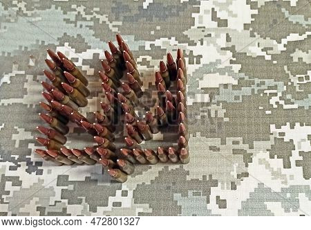 Coat Of Arms Of Ukraine Laid Out From Cartridges Against Background Of Camouflage Clothing. Cartridg