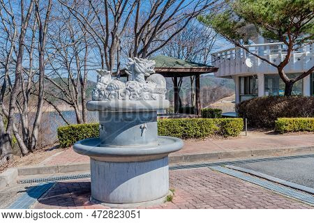 Cement Water Fountain With Stone Carved Dragon Capstone At Roadside Park.