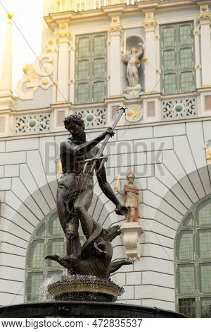 Statue Of Neptune Fountain In Old Town Of Gdansk, Poland. Fountain Of The Neptune And City Hall. Old