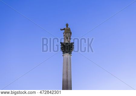 Statue Of Minerva On The Colonna Di Minerva And Galleria Degli Antichi Against The Blue Sky. Sabbion