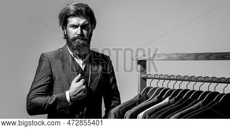 Tailor, Tailoring. Mens Suit, Tailor In His Workshop. Elegant Mans Suits Hanging In A Row. Luxury Me