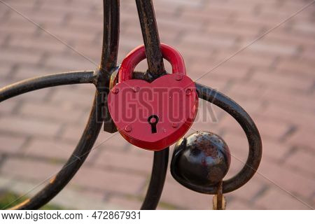 A Large Red Lock Hangs On An Iron Structure. He Was Hanged By The Newlyweds.