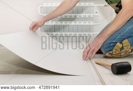 Man Lays Heat-insulating Sheets On The Floor Under The Laminate. Repair And Decoration Of Premises. 