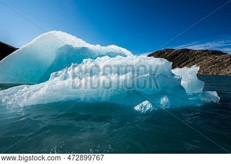 Chunk Of Glacier Ice Lit By Rising Sun Folgefonna Glacier Mosevatnet Lake, Norway