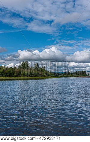 Fairbanks, Alaska, Usa - July 27, 2011: Chena River Portrait, Blueish Water Under Blue Cloudscape An
