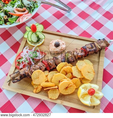 Greek Kontosouvli Large Souvlaki Made By Fresh Meat Grilled On Fire And Served With French Fries.