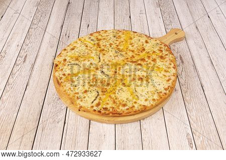 Freshly Baked Four Formaggio Pizza With Oregano And Mozzarella Cheese On Wooden Board