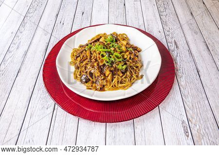 Udon Noodles Sauteed With Chinese Mushrooms And Beef With Chopped Chives On Top And Soy Sauce Season