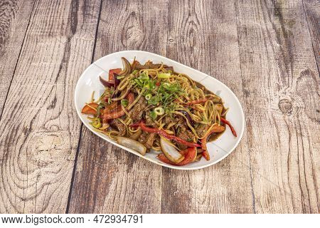 Peruvian Sautéed Noodles With Strips Of Tenderloin, Onion Pieces, Tomato, Red Pepper And Green Chive