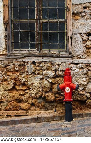 Close-up - Overhead Red Pressurized Fire Hydrant Against  Stone House
