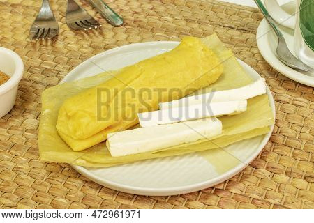 Peruvian-style Salty Humita Tamale With Cheese Served On Yellow Corn Husk
