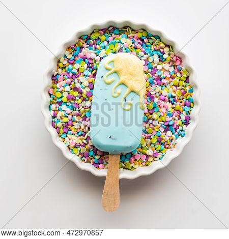 A Springtime Decorated Cakesicle In A Bowl Full Of Pastel Confetti Sprinkles.