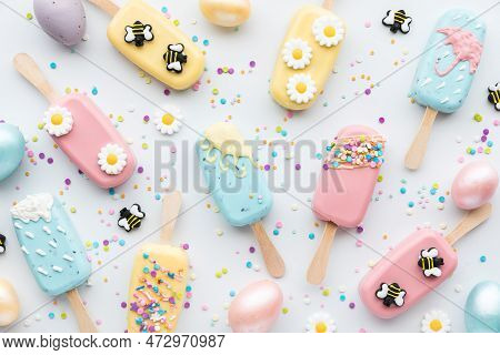 Top Down View Of Several Homemade Cakesicles Decorated For Spring.