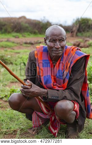 Africa, Kenya, May, 2016 - Portrait Of Old African Men Sitting On A Green Meadow In Masai Tribe Vill
