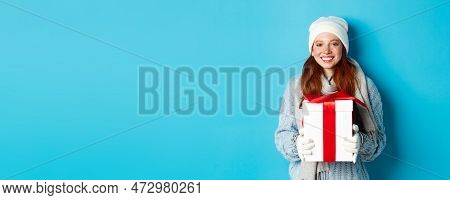 Winter Holidays And Christmas Sales Concept. Cute Redhead Teeanage Girl In Beanie, Sewater And Scarf