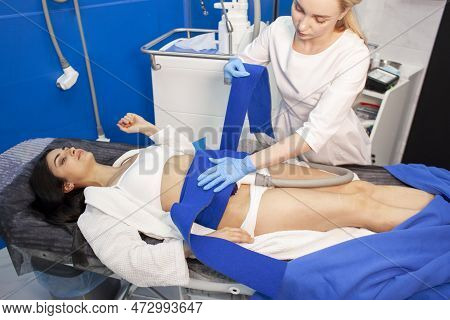 Coolsculpting Procedure In Cosmetology Clinic, Girl Patient Lies On Couch And Cosmetologist Doctor M