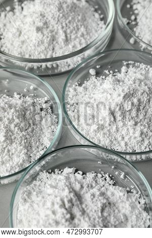 Petri Dishes With Calcium Carbonate Powder On Grey Table, Closeup